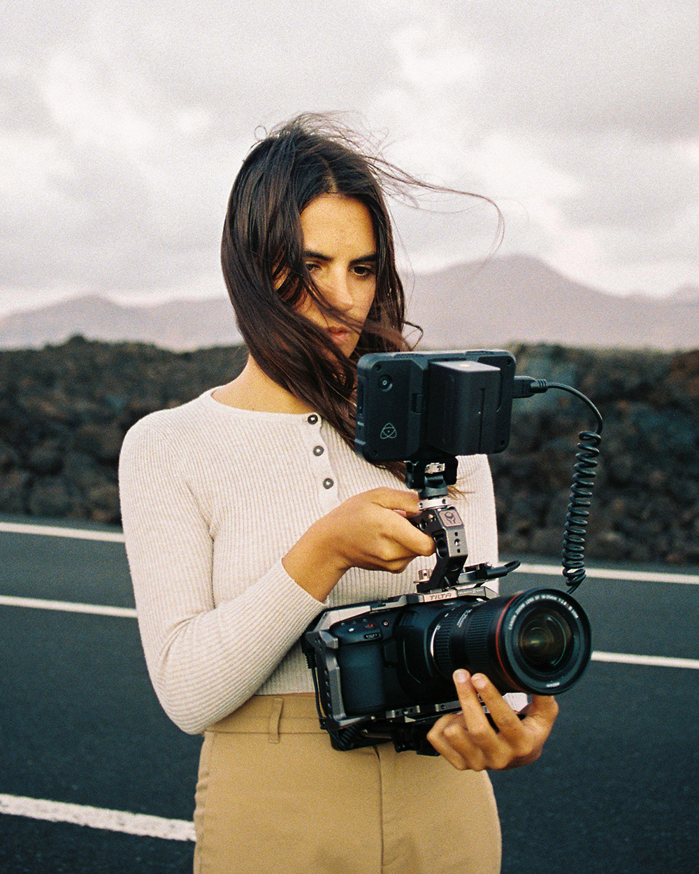 Photo of Giulia with her camera gears, filming a desert road